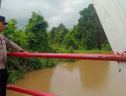 Personil Bhabinkamtibmas Polsek Muara Kuang Cek Ketinggian Air Sungai di Muara Kuang